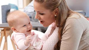 Mum holing giggling baby girl